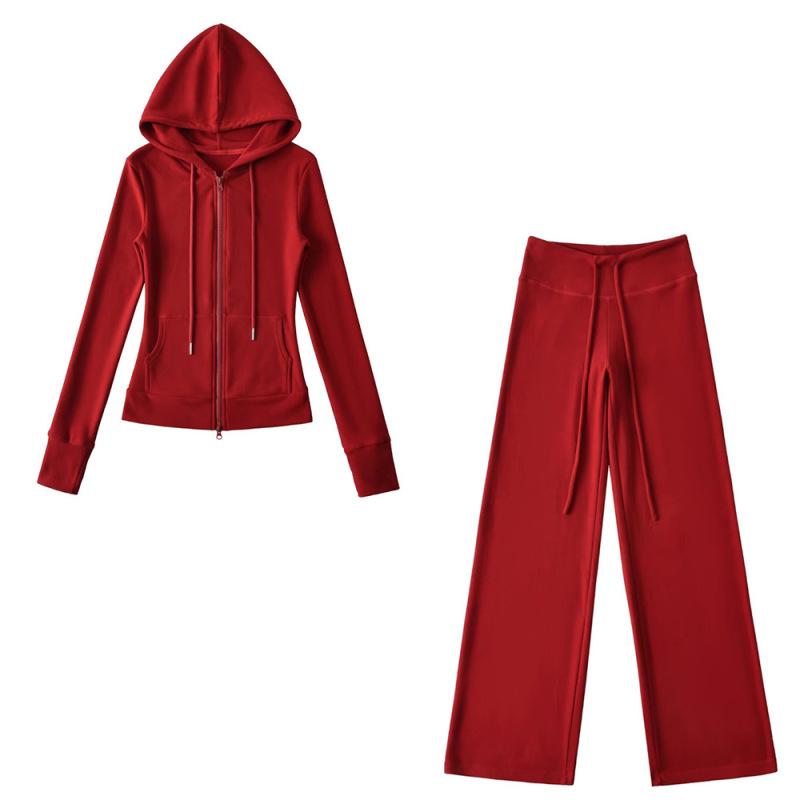 Relaxed fit red tracksuit with long-sleeved hooded zip-up jacket and loose drawstring wide-leg pants.
