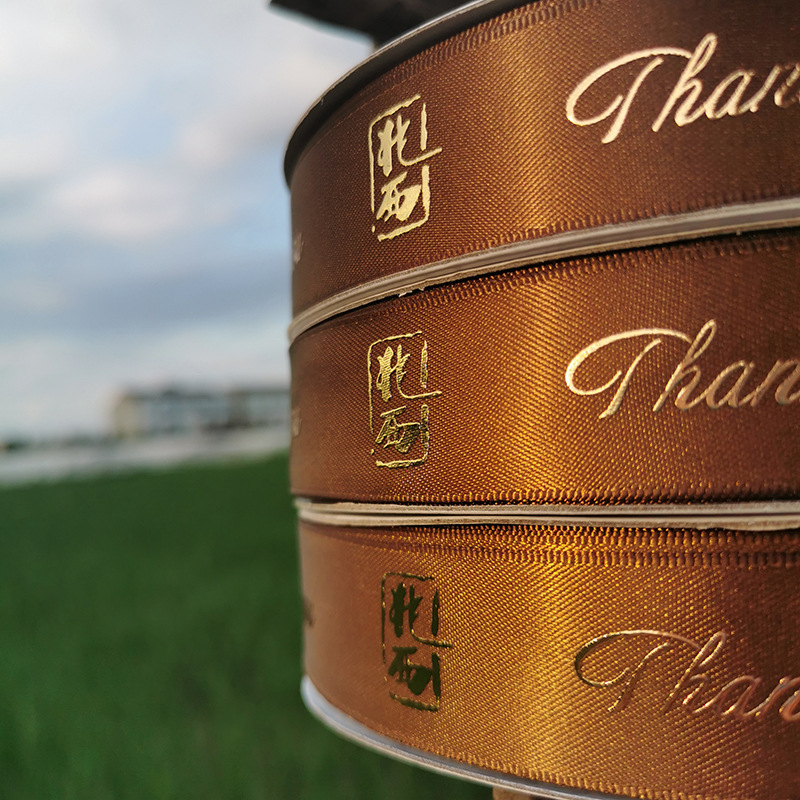 Custom-made ribbons with printed logos, 3D embossed lettering, hot stamping, gold and silver lettering, creative and high-quality ribbon manufacturer.