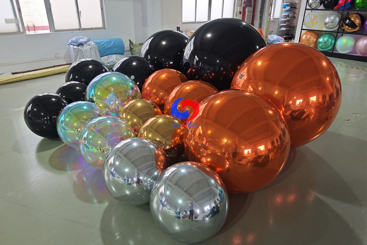 giant black shiny spheres giant orange silver gold iridescent shiny ballons