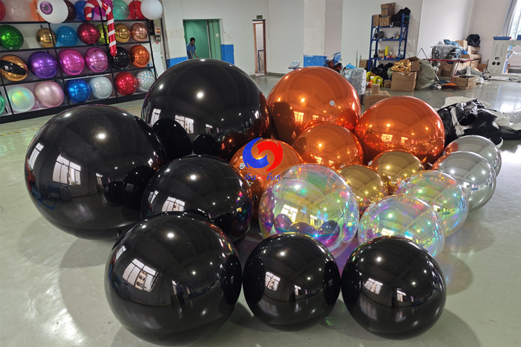 giant black shiny spheres giant orange silver gold iridescent shiny ballons