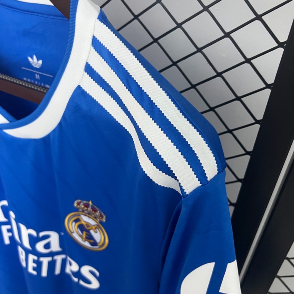Shoulder detail of 2025-26 Real Madrid second away jersey fan version, highlighting Adidas triple stripes and Real Madrid crest.