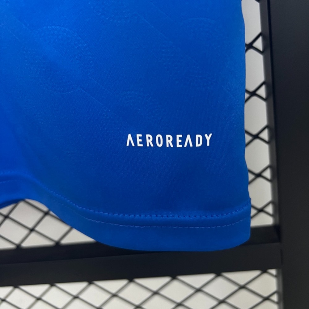 Collar and shoulder detail of the 2025-26 Real Madrid second away jersey fan version, featuring blue and white contrast neckline with Adidas triple stripes.