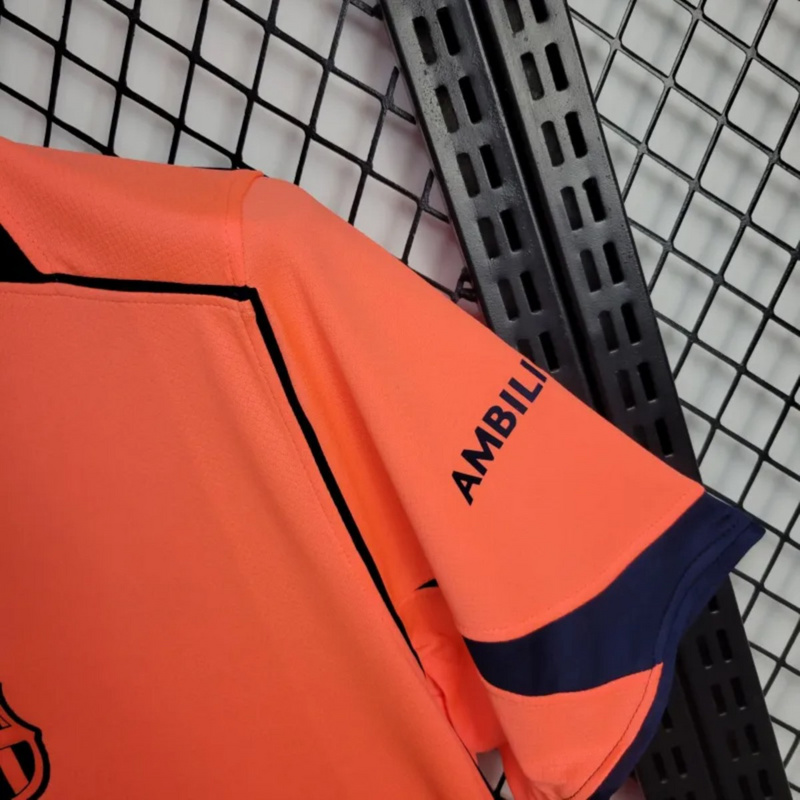 2025-26 FC Barcelona Second Away Jersey sleeve detail showing AMBILIGHT TV sponsor logo and navy trim on bright orange fabric.