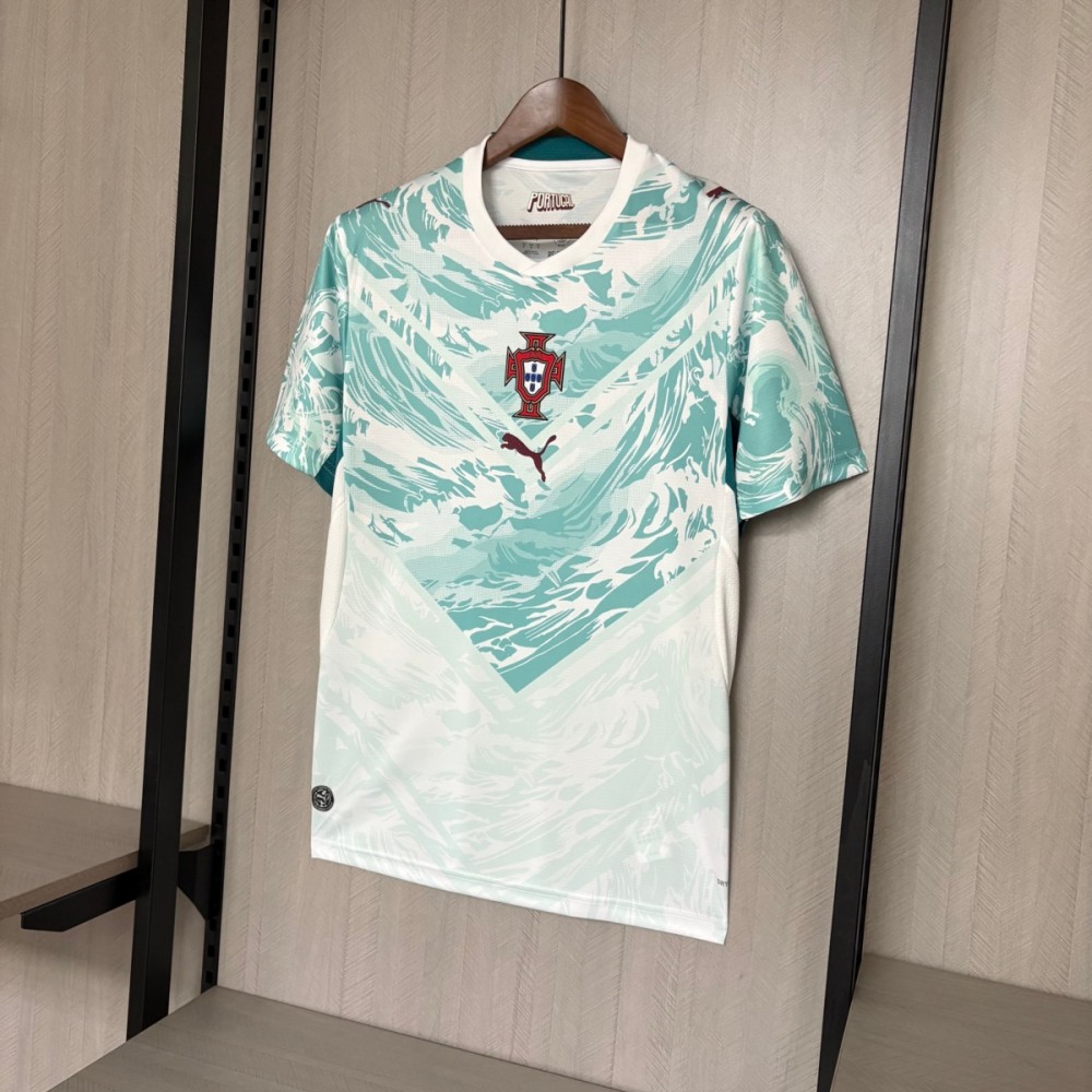 Full front view of the Portugal 2026 World Cup away fan version jersey featuring a white base with teal wave graphics, central Portugal crest, and Puma logo.