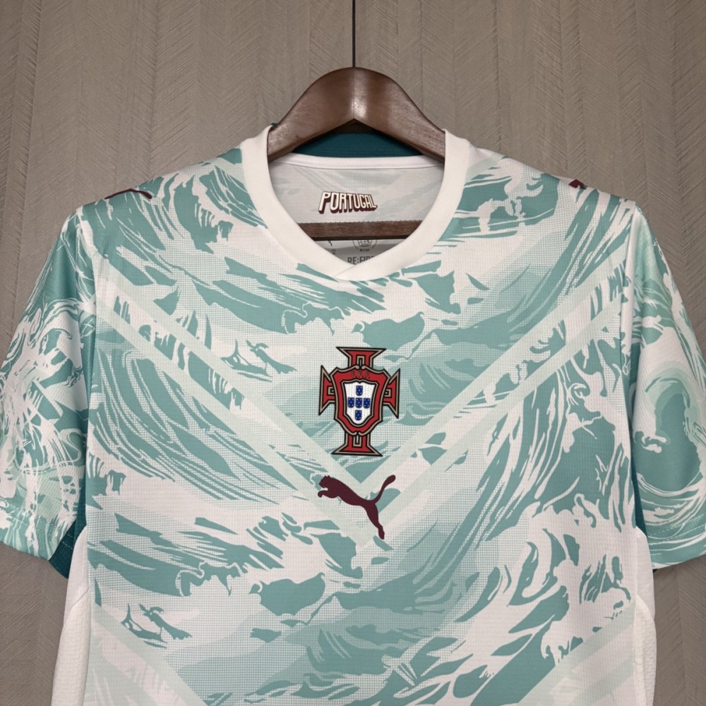 Upper front view of the Portugal 2026 World Cup away jersey fan version featuring the Portugal crest centered on the chest, Puma logo below, and a white base with teal wave graphic design.