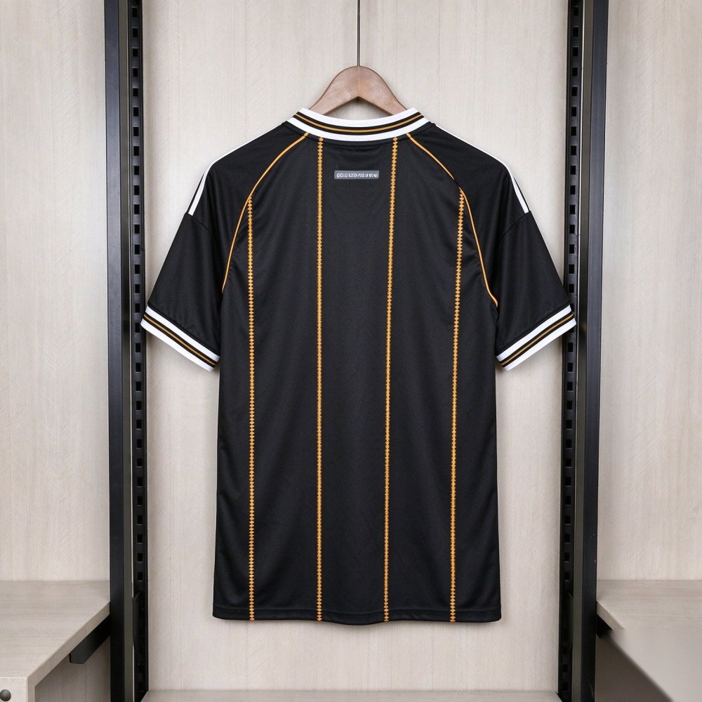 Germany 2026-27 third shirt back - the same black body with six vertical lines of small gold diamonds from collar to hem, a white rib collar with black-and-gold edging seen from behind, a small grey woven label with a light wordmark below the back of the collar, three white stripes over each shoulder, and a completely blank lower back; no name and no number