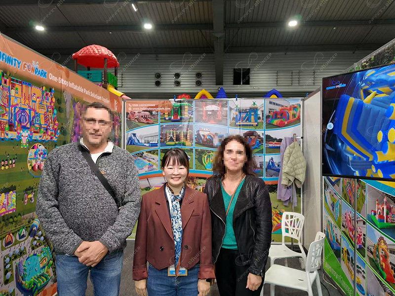Infinity Bounce Park team and international clients at SETT 2025 exhibition booth showcasing inflatable bouncy castles and combo products