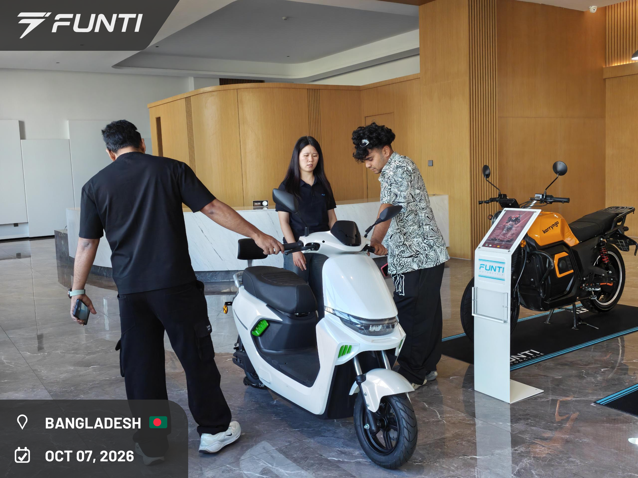 The visiting customer from Bangladesh with the FUNTI team in the showroom, alongside the models on display, October 7, 2026