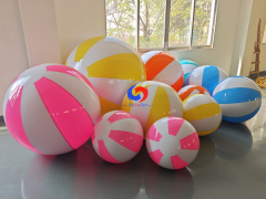 Glossy giant yellow‑white striped inflatable beach balls in mixed sizes