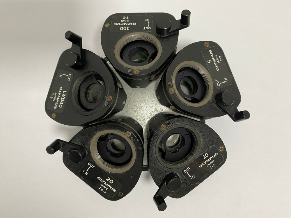 Used Olympus 5-position microscope nosepiece with DIC prisms set top view