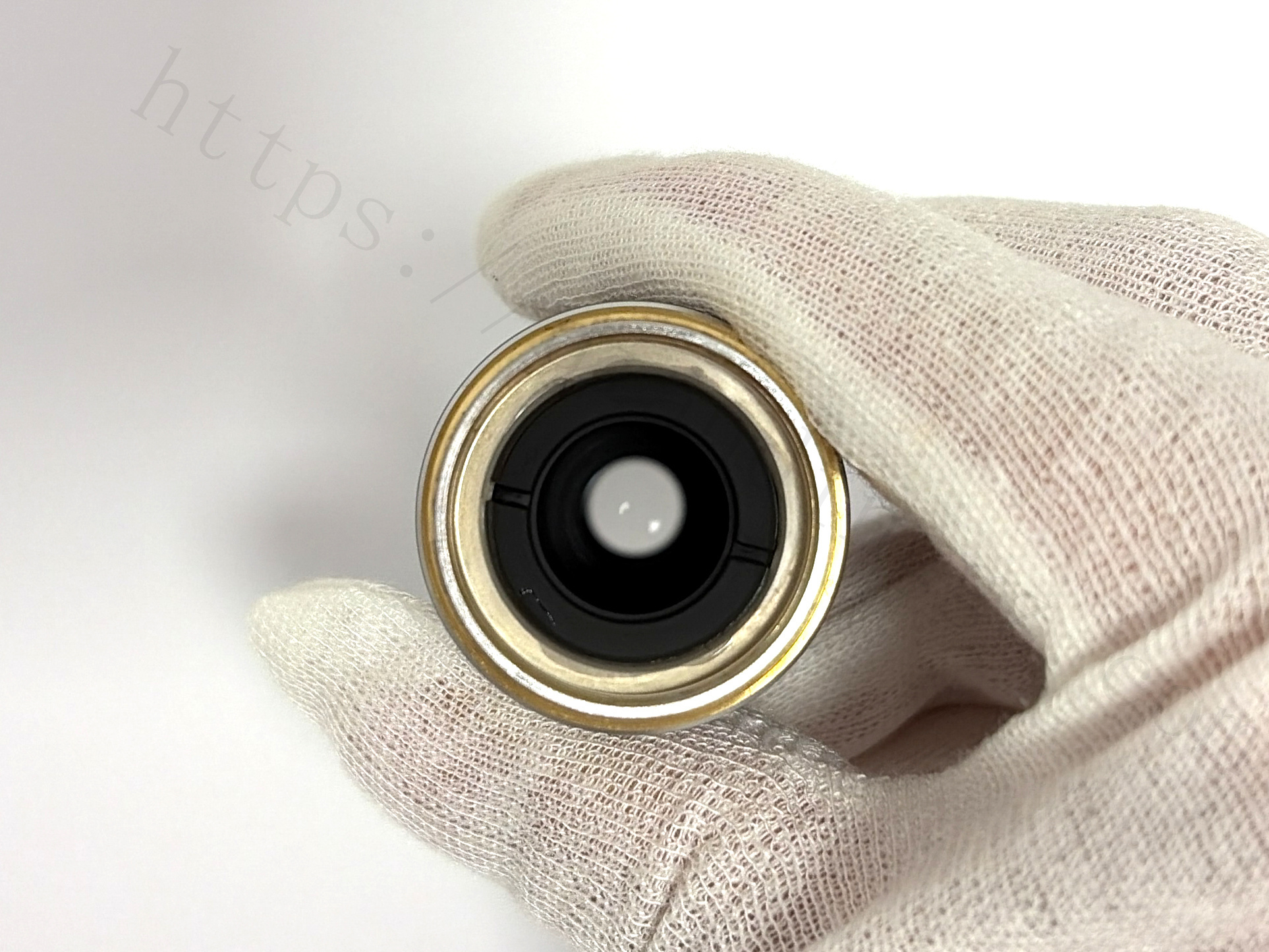 Top screw thread view of Nikon Plan 20X objective lens held in gloved hand