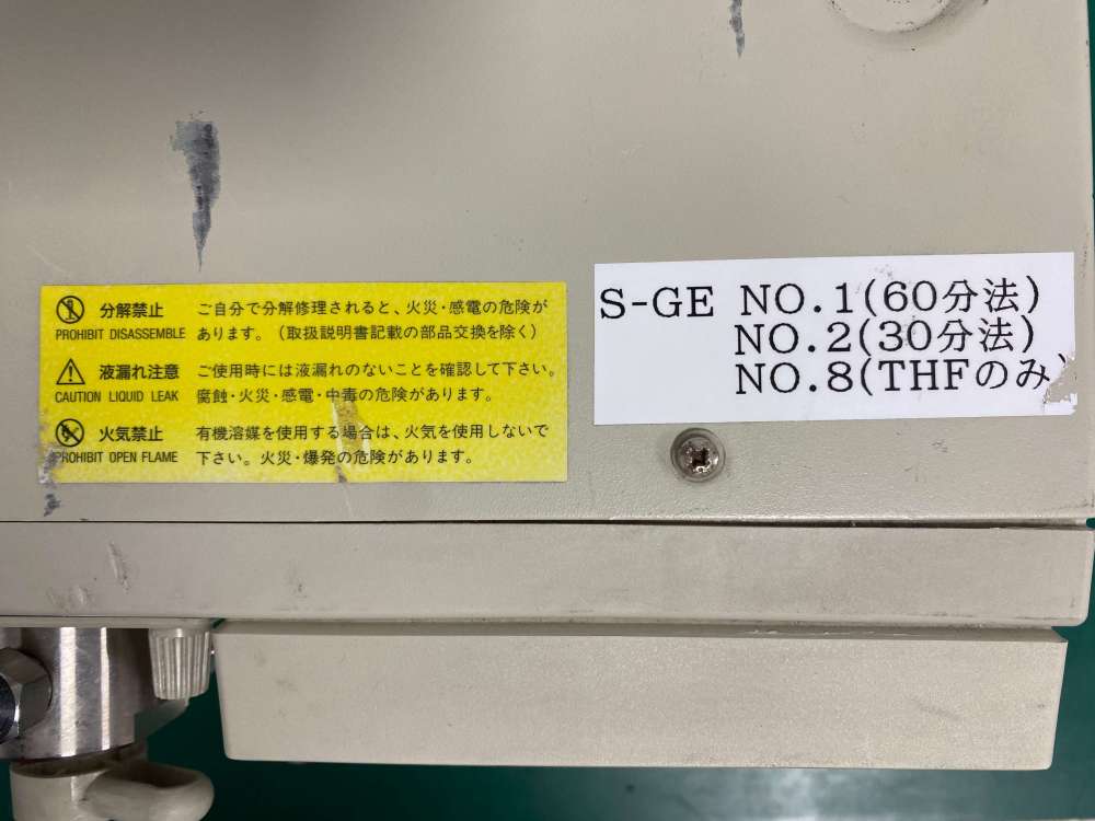 Close-up of the Japanese warning labels and program mode guide sticker on a Tosoh DP-8020 pump