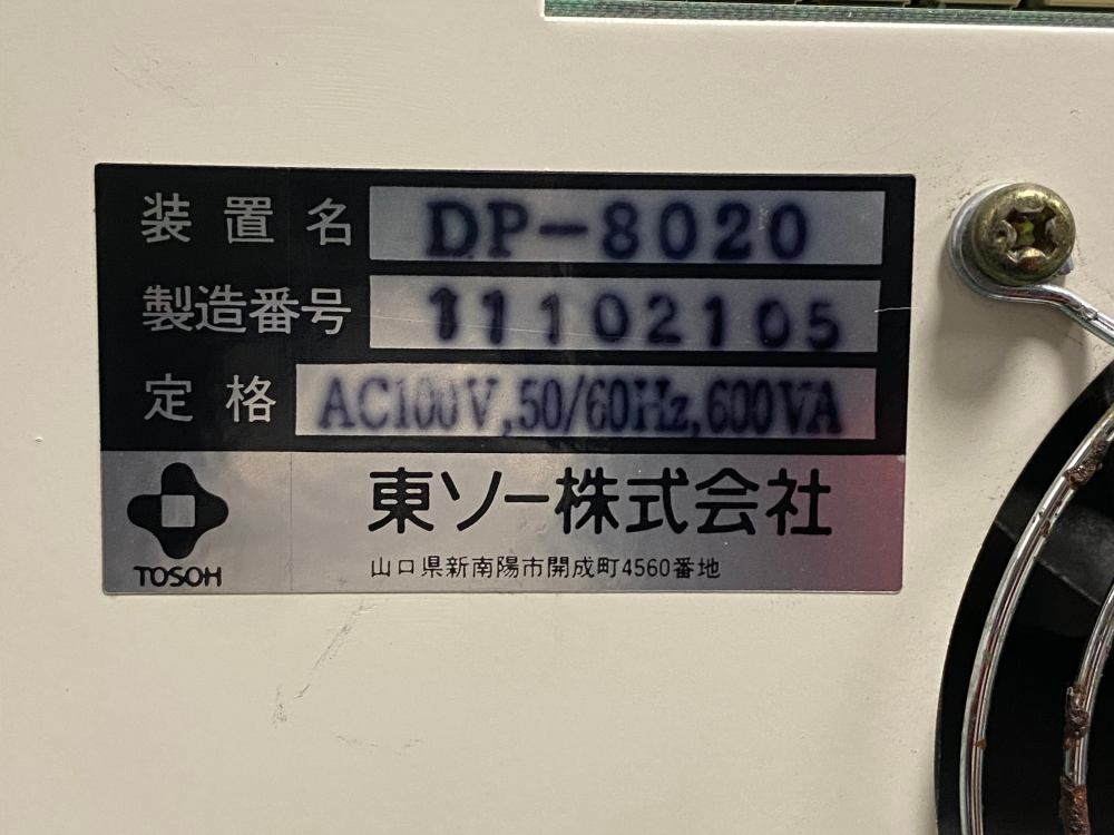 Detailed close-up of Tosoh DP-8020 specification plate showing serial number 11102105, AC100V power rating, and manufacturer Tosoh Corporation Japan