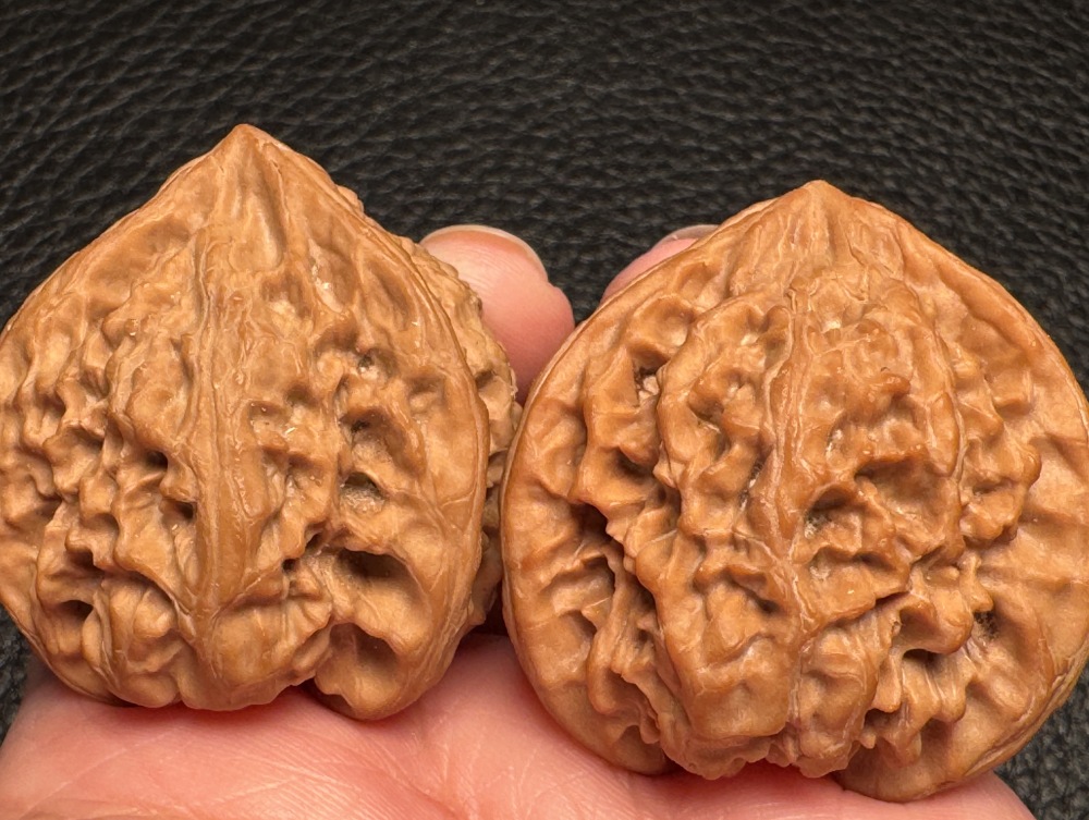 Chinese intangible cultural heritage cultural items featuring walnut nuts and wild oxen running towards a triangular shape. Hand-held pieces for health preservation and excellent therapeutic items.
