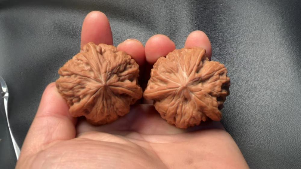 Hand-held walnuts, concave bottom, perfectly triangular shape, high-end and elegant, exquisite pair, red skin, mountain-grown fruit. A fine pair, perfect for personal enjoyment or as a gift.
