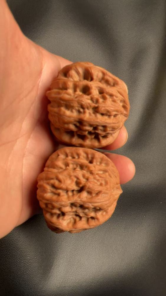 Hand-held walnuts, concave bottom, perfectly triangular shape, high-end and elegant, exquisite pair, red skin, mountain-grown fruit. A fine pair, perfect for personal enjoyment or as a gift.