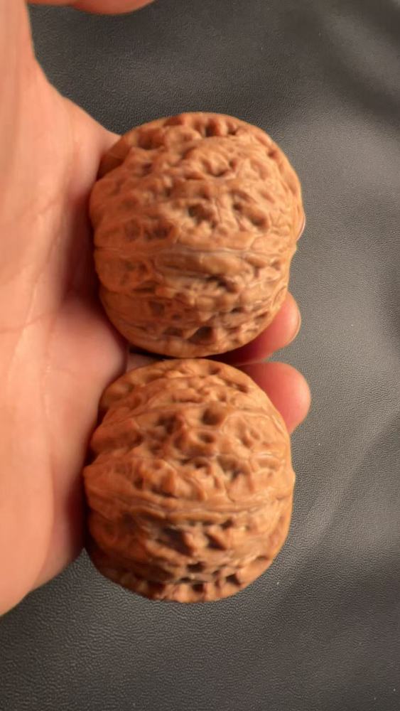 Hand-held walnut "Iron Hammer" variety, heavy texture, shallow patterns, quick coloring, flawless condition, exquisite pair, high-end niche variety, perfect gift for your girlfriend, may help prevent Alzheimer's disease, promote health and wellness.