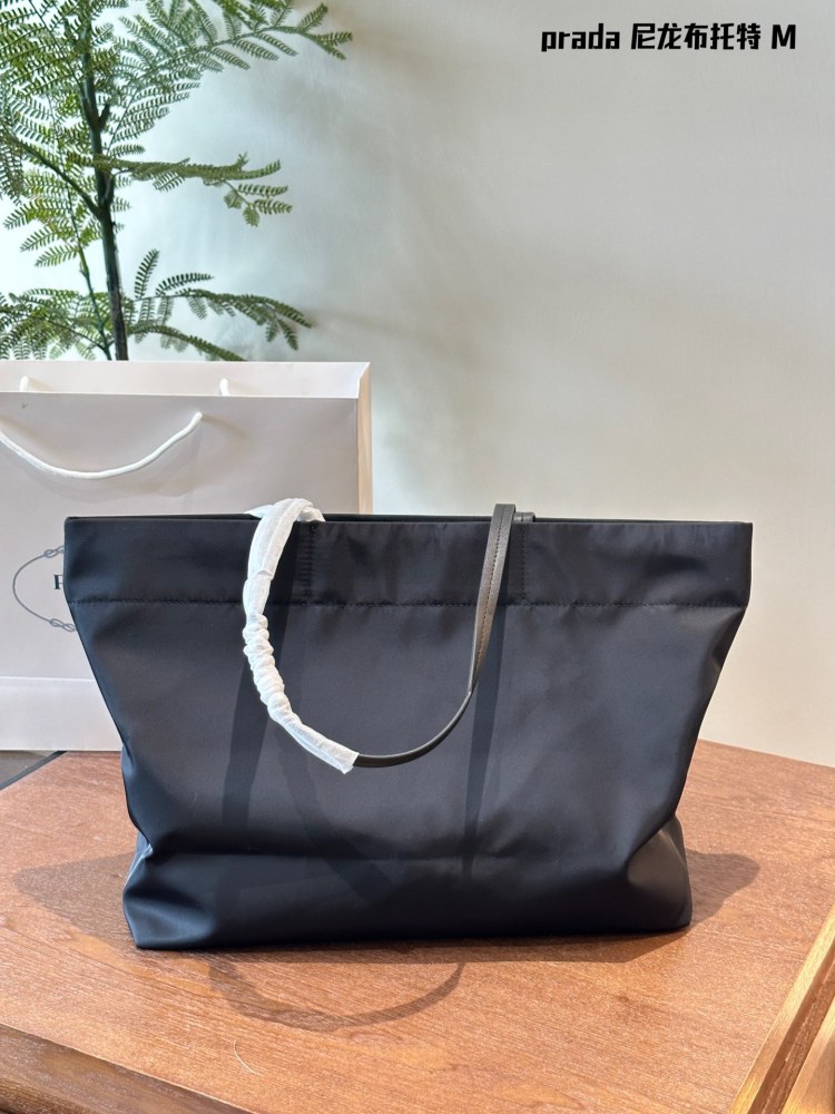 Prada。 P190 comes with a box
This medium-sized tote bag is made of innovative recycled nylon fabric, with a simple and stylish design. The bag is equipped with exquisite Saffiano leather handles, adorned with the iconic enamel coated triangular met...