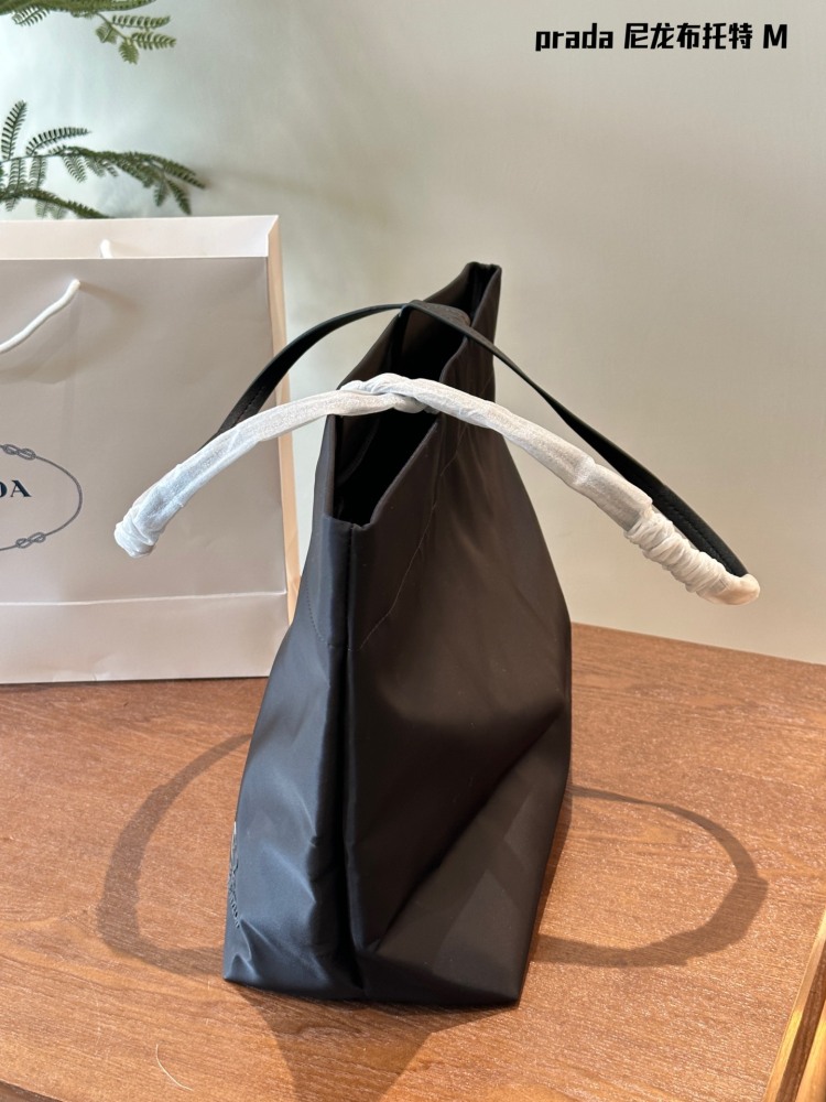Prada。 P190 comes with a box
This medium-sized tote bag is made of innovative recycled nylon fabric, with a simple and stylish design. The bag is equipped with exquisite Saffiano leather handles, adorned with the iconic enamel coated triangular met...