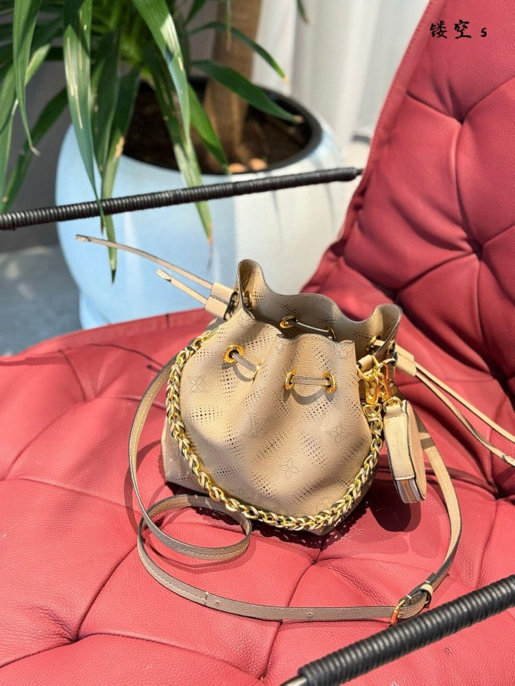 p270
The LV bucket bag series uses embossed perforated cowhide leather for this Bella handbag, which shines with metallic luster in a lightweight texture. The drawstring is used to fold up the water bucket, and the chain and leather woven handle are ...