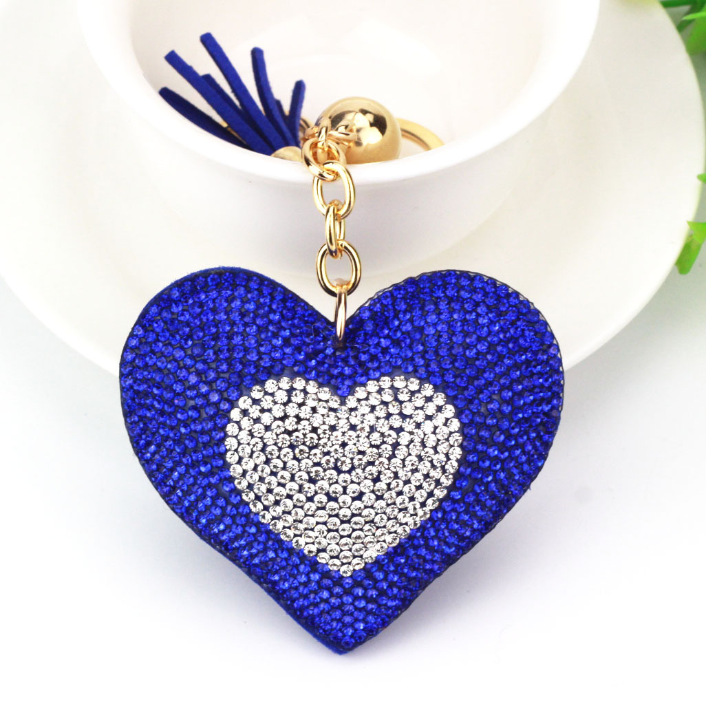 Wholesale two-tone heart-shaped keychains with rhinestone embellishments and heart-shaped tassels for bags and car hangings.
