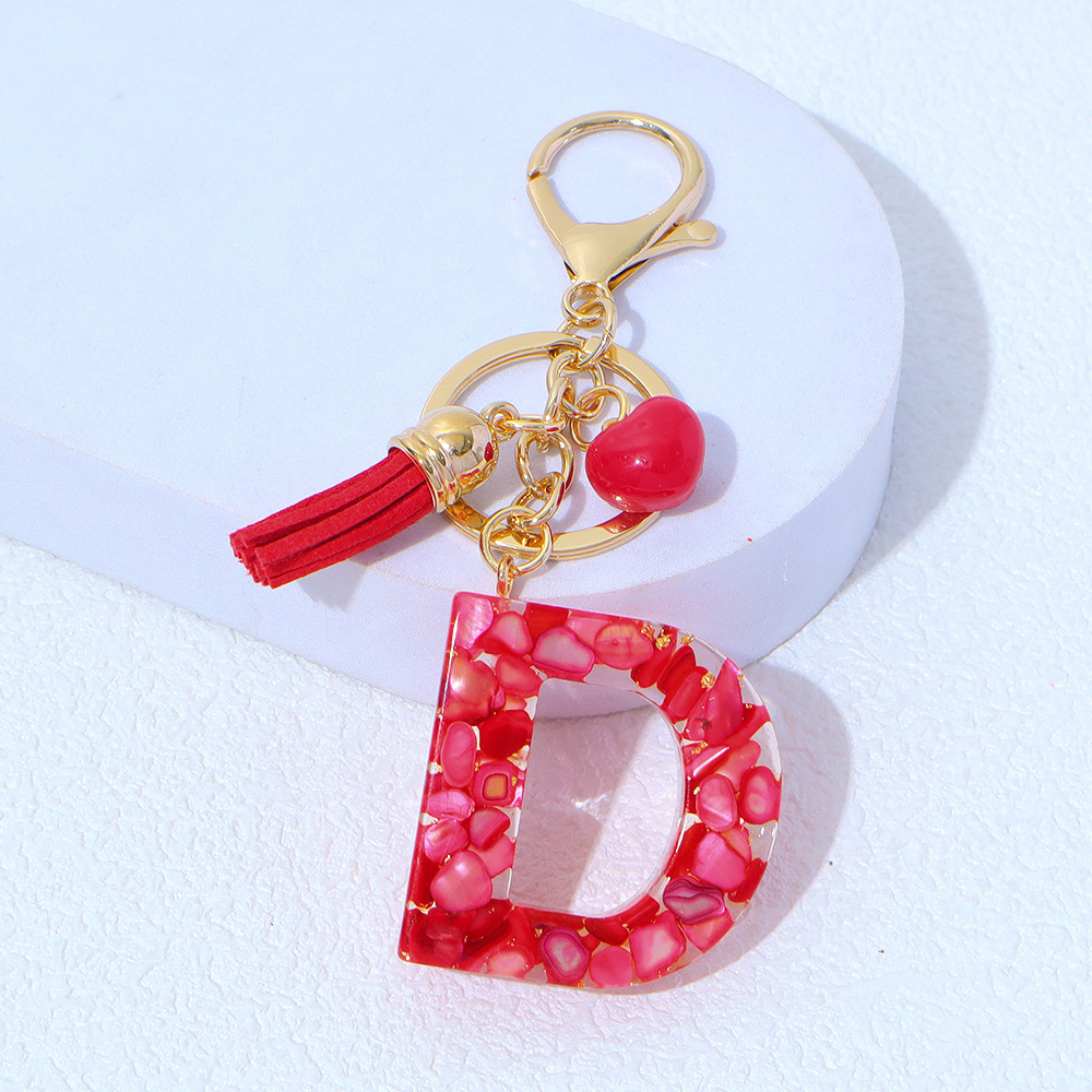 Wholesale red stone-filled letter keychains, resin heart tassel pendants, bag charms, party gifts.