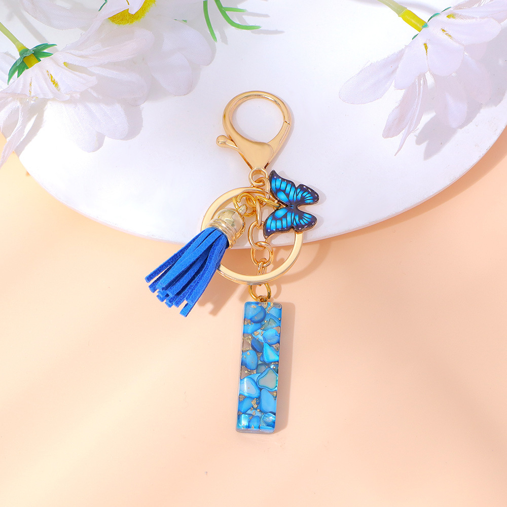 Wholesale blue stone gold foil English letter keychains, tassel butterflies, women's bag charms, souvenirs.