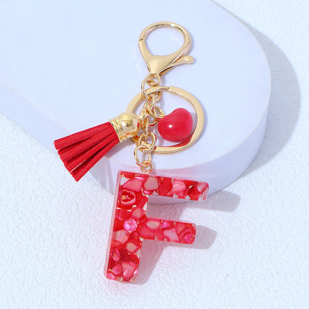 Wholesale red stone-filled letter keychains, resin heart tassel pendants, bag charms, party gifts.