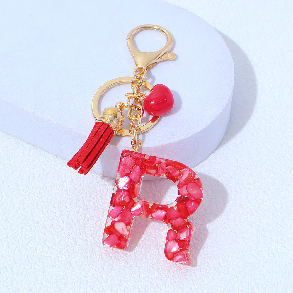 Wholesale red stone-filled letter keychains, resin heart tassel pendants, bag charms, party gifts.