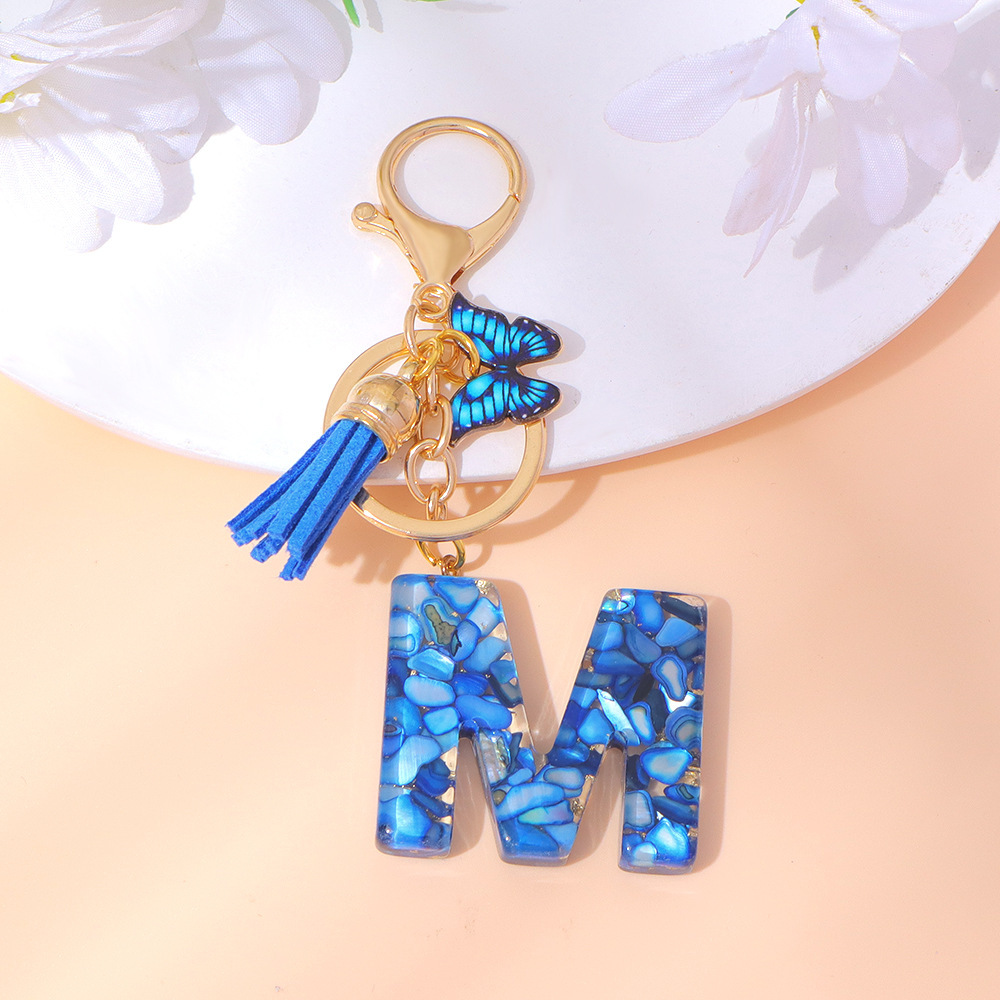 Wholesale blue stone gold foil English letter keychains, tassel butterflies, women's bag charms, souvenirs.