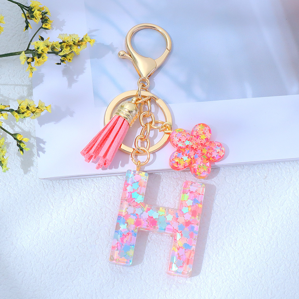 Wholesale pink star sequined epoxy resin letter keychains, flower pendants, DIY bag charms, perfect for gifting to your best friend.