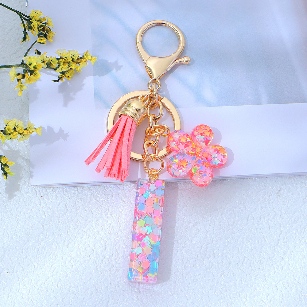 Wholesale pink star sequined epoxy resin letter keychains, flower pendants, DIY bag charms, perfect for gifting to your best friend.