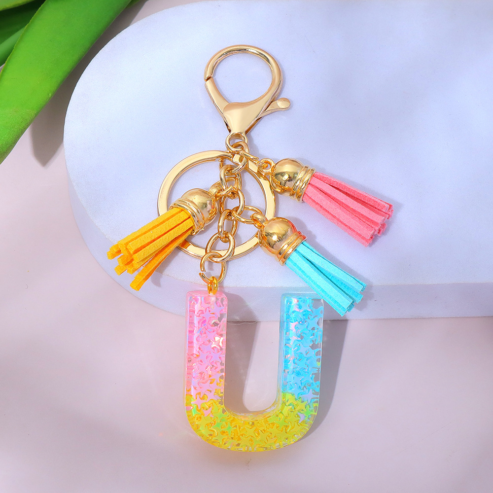 Wholesale star-studded sequin-filled letter keychains, tassel resin pendant keychains, and souvenir decorations for women's backpacks.
