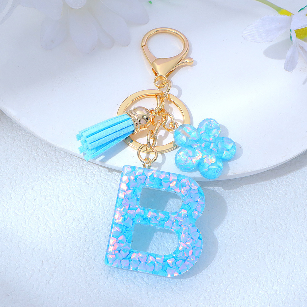 Wholesale blue crystal epoxy letter keychains, letter pendants, flower charms, and bag decorations.