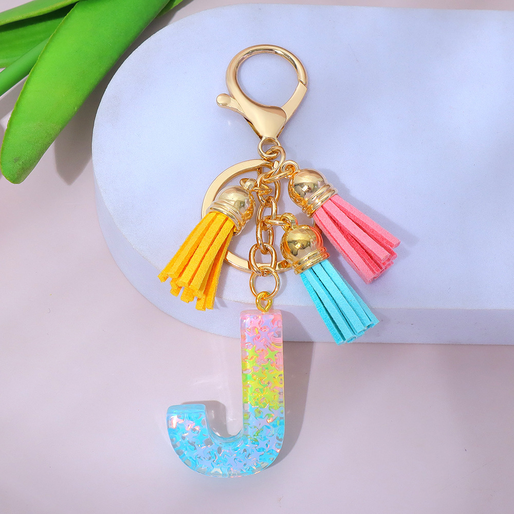 Wholesale star-studded sequin-filled letter keychains, tassel resin pendant keychains, and souvenir decorations for women's backpacks.
