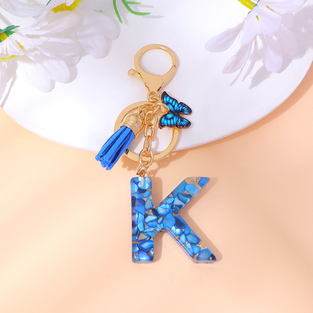 Wholesale blue stone gold foil English letter keychains, tassel butterflies, women's bag charms, souvenirs.