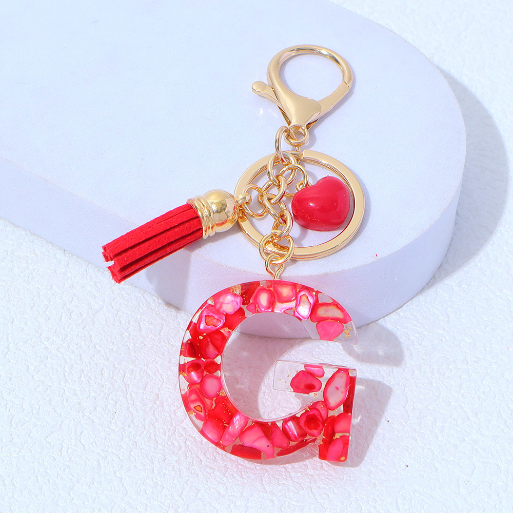 Wholesale red stone-filled letter keychains, resin heart tassel pendants, bag charms, party gifts.