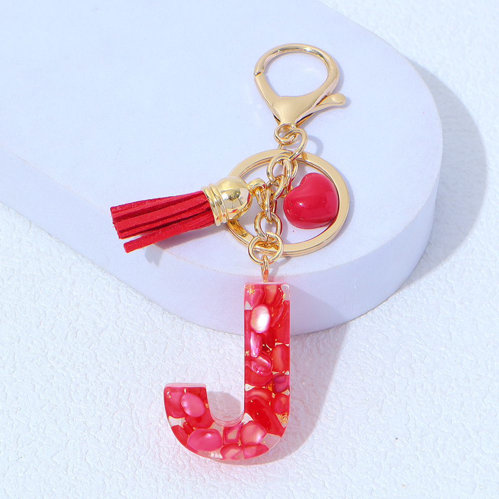 Wholesale red stone-filled letter keychains, resin heart tassel pendants, bag charms, party gifts.