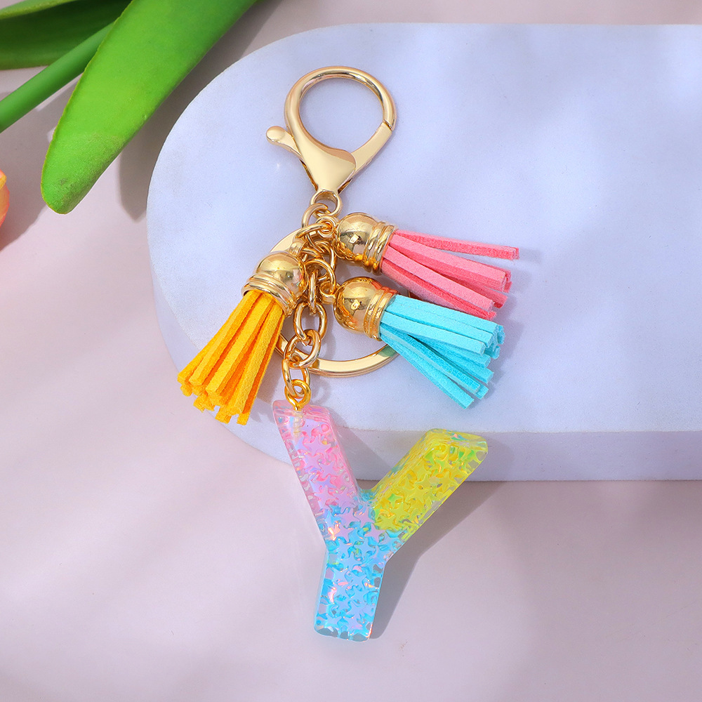 Wholesale star-studded sequin-filled letter keychains, tassel resin pendant keychains, and souvenir decorations for women's backpacks.