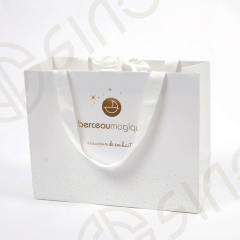 Simple white bag with gold logo and crosgrain ribbon decorate