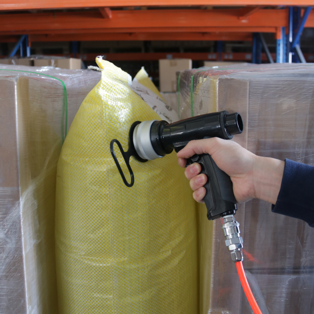 Hand using inflator air gun to quickly fill a dunnage bag