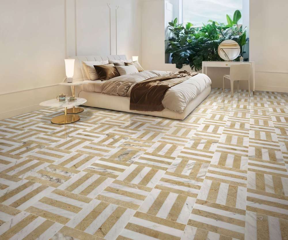 Elegant master bedroom featuring 12x12 Snow Mountain White and Hyatt Gold waterjet marble tiles installed in a checkerboard floor pattern. The warm gold tones of the natural stone complement the soft bedding and natural light from the large window.