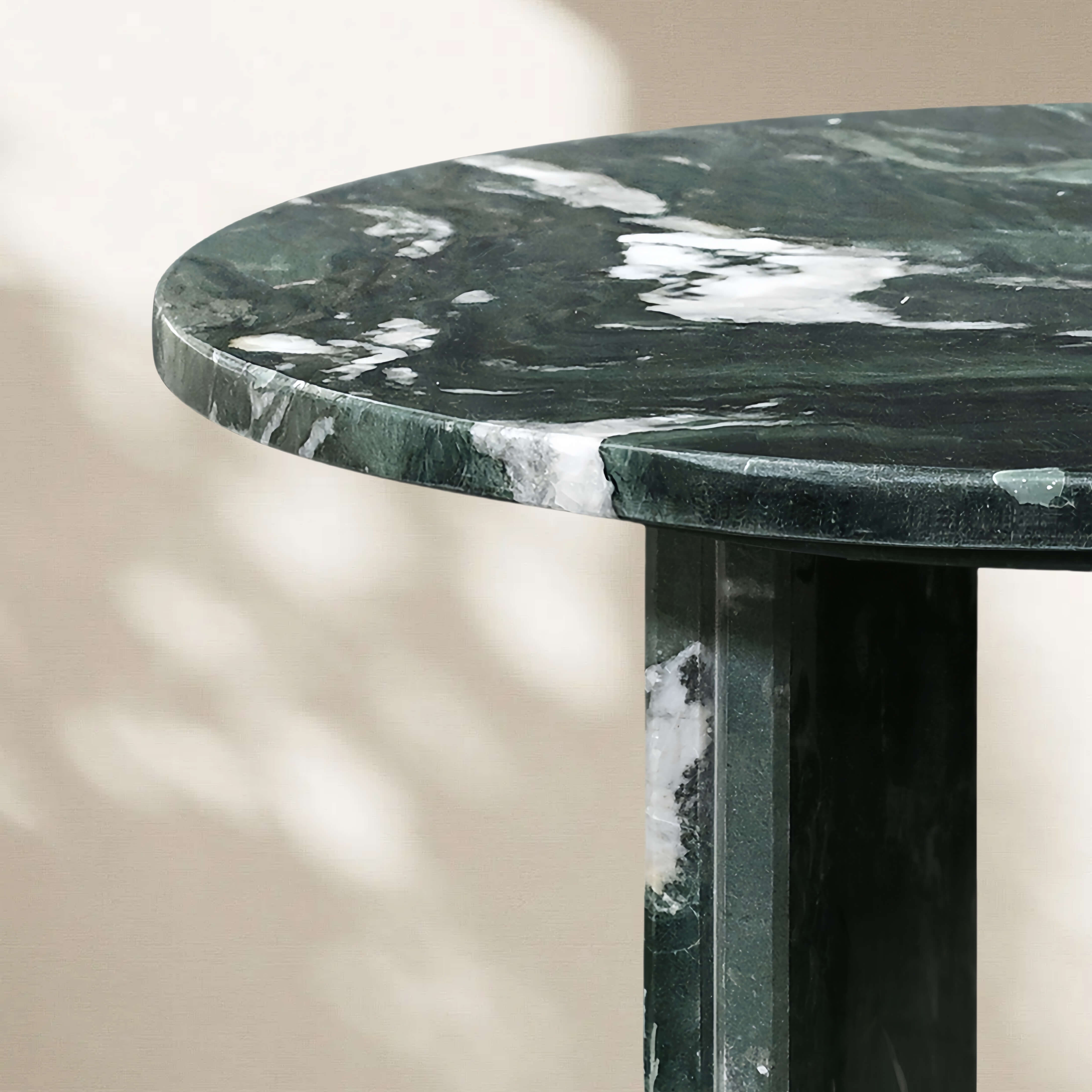 Close-up detail of the green marble tabletop edge showing the thickness and polished finish with natural white veining.