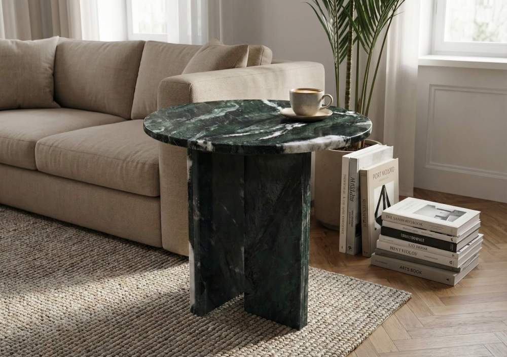 Contemporary luxury apartment living room setup featuring a green marble table beside a sofa and art books.