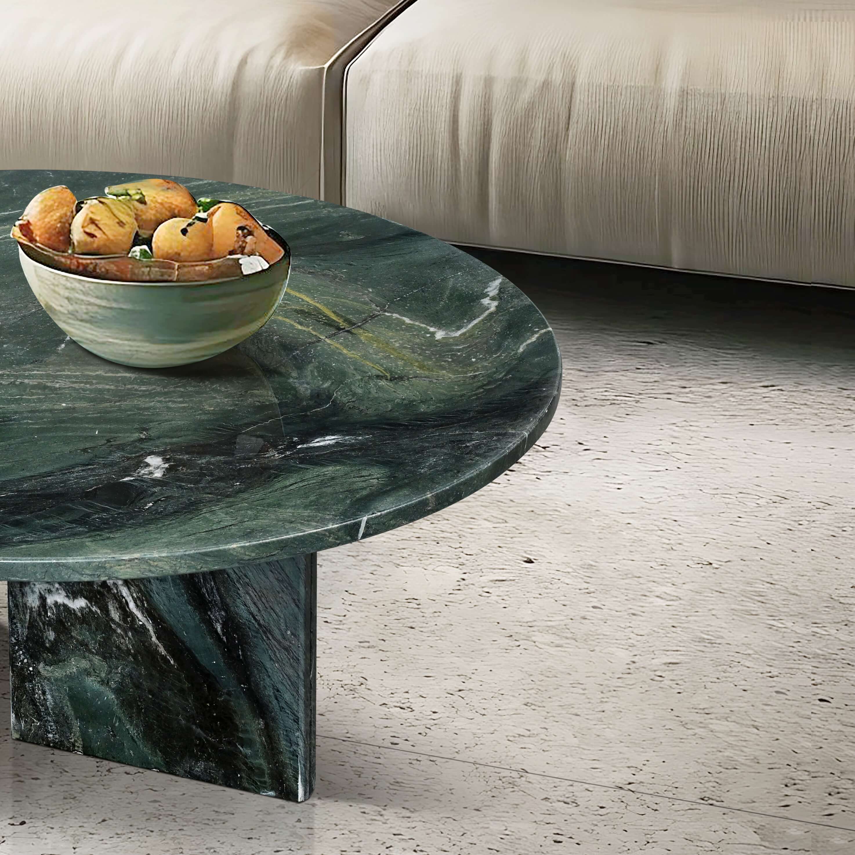 Lifestyle close-up of the green marble table top styled with a decorative bowl, showing the rich depth and texture of the natural stone surface.