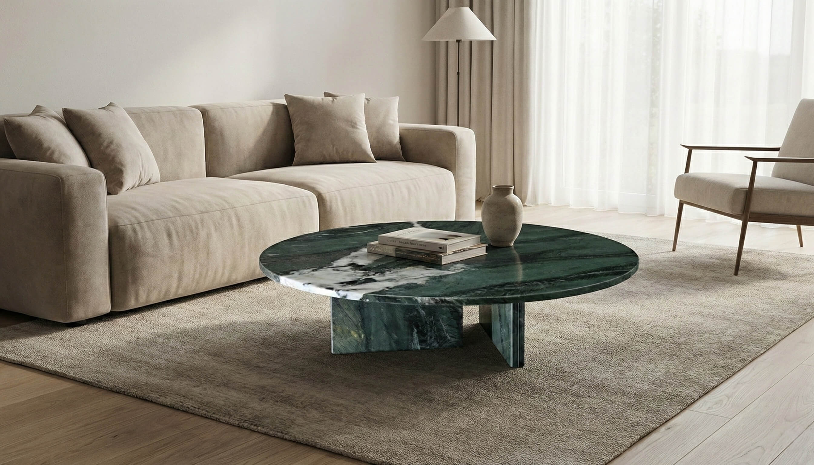 A 90cm Diamond Green marble round coffee table centered in a minimalist living room, featuring a cross-base design and placed on a beige rug.