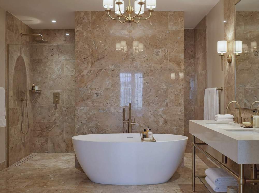 Stunning bathroom shower design utilizing 12x24 inch Hyatt Gold natural marble tiles, creating a high-end, exclusive spa-like atmosphere with entirely unique patterns.