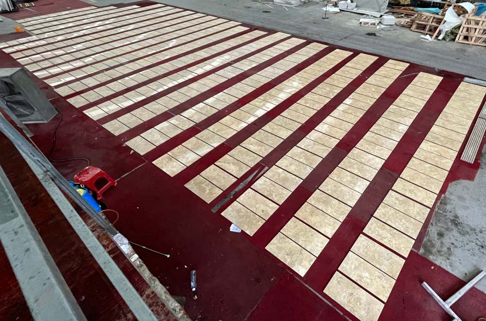 Large scale production and quality check of 12x24 inch Hyatt Gold natural marble tiles, guaranteeing that every unique piece meets high-end project standards.