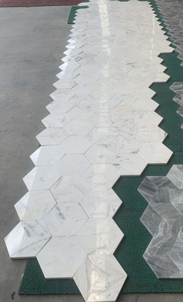 Large-scale layout of Snow Mountain White polished hexagon marble tiles demonstrating elegant, natural shade variations for luxury commercial or residential projects.