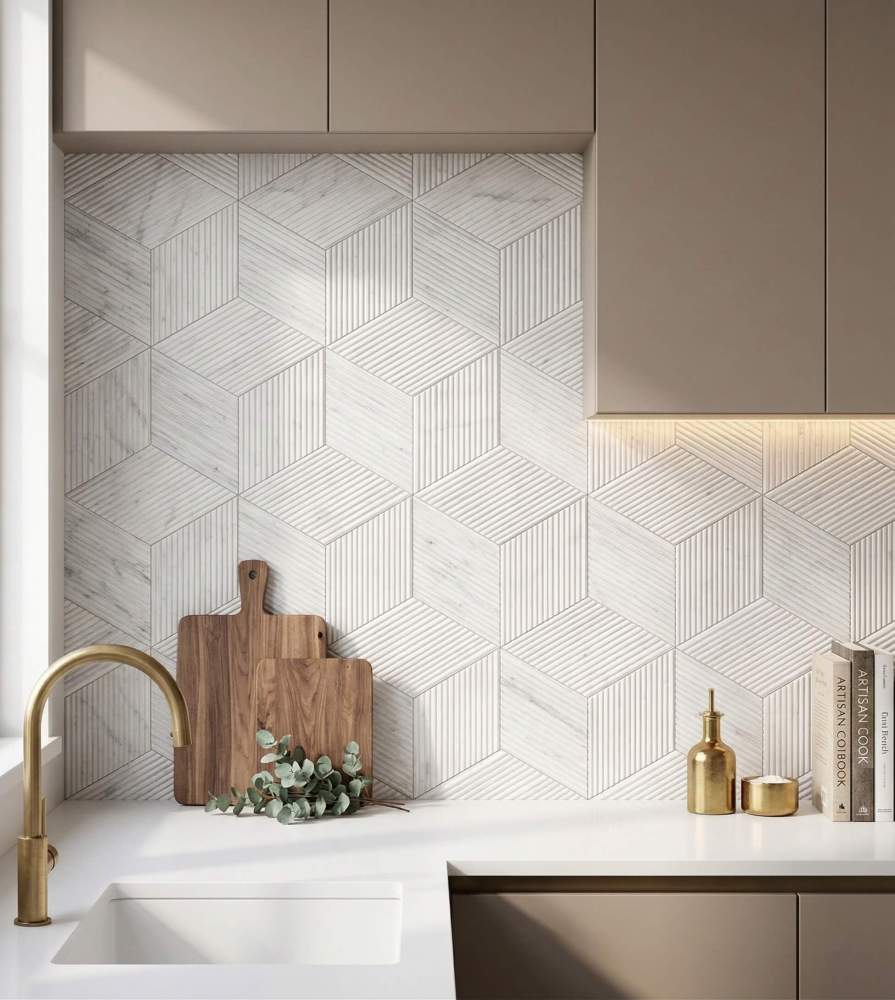 Modern kitchen backsplash illuminated by under-cabinet lighting, beautifully highlighting the rich 3D texture of the natural Snow Mountain White hexagon marble tiles.